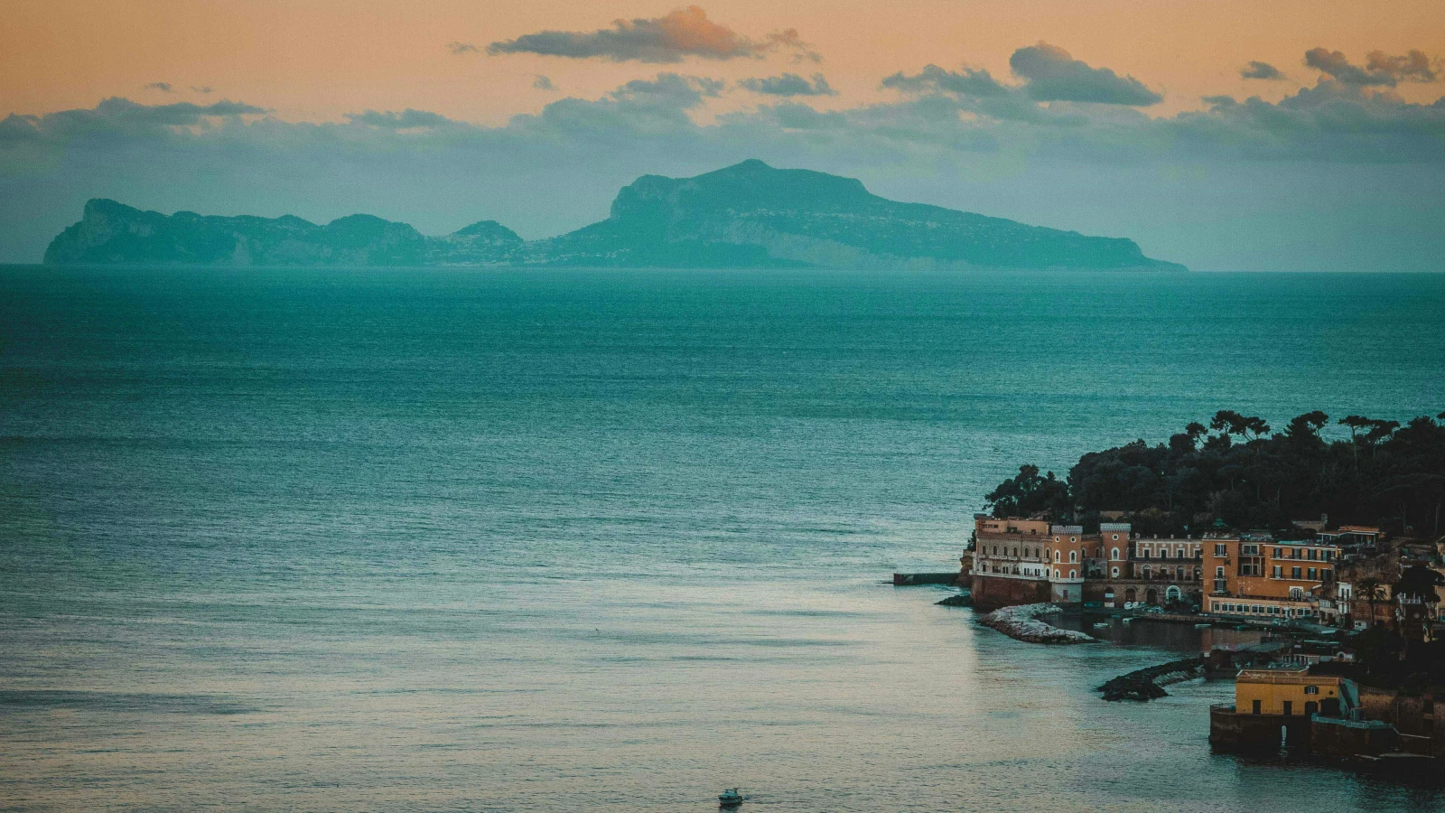 Orange buildings along Napoli waterfront - electric car hire and hybrid vehicle options