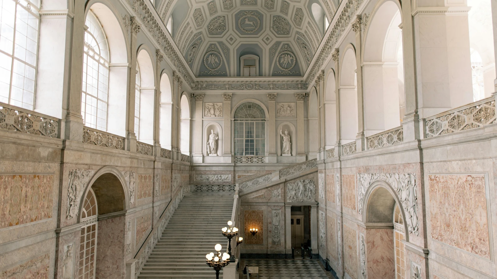 Large ornate room with tall windows inside the Royal Palace of Naples Palazzo Reale