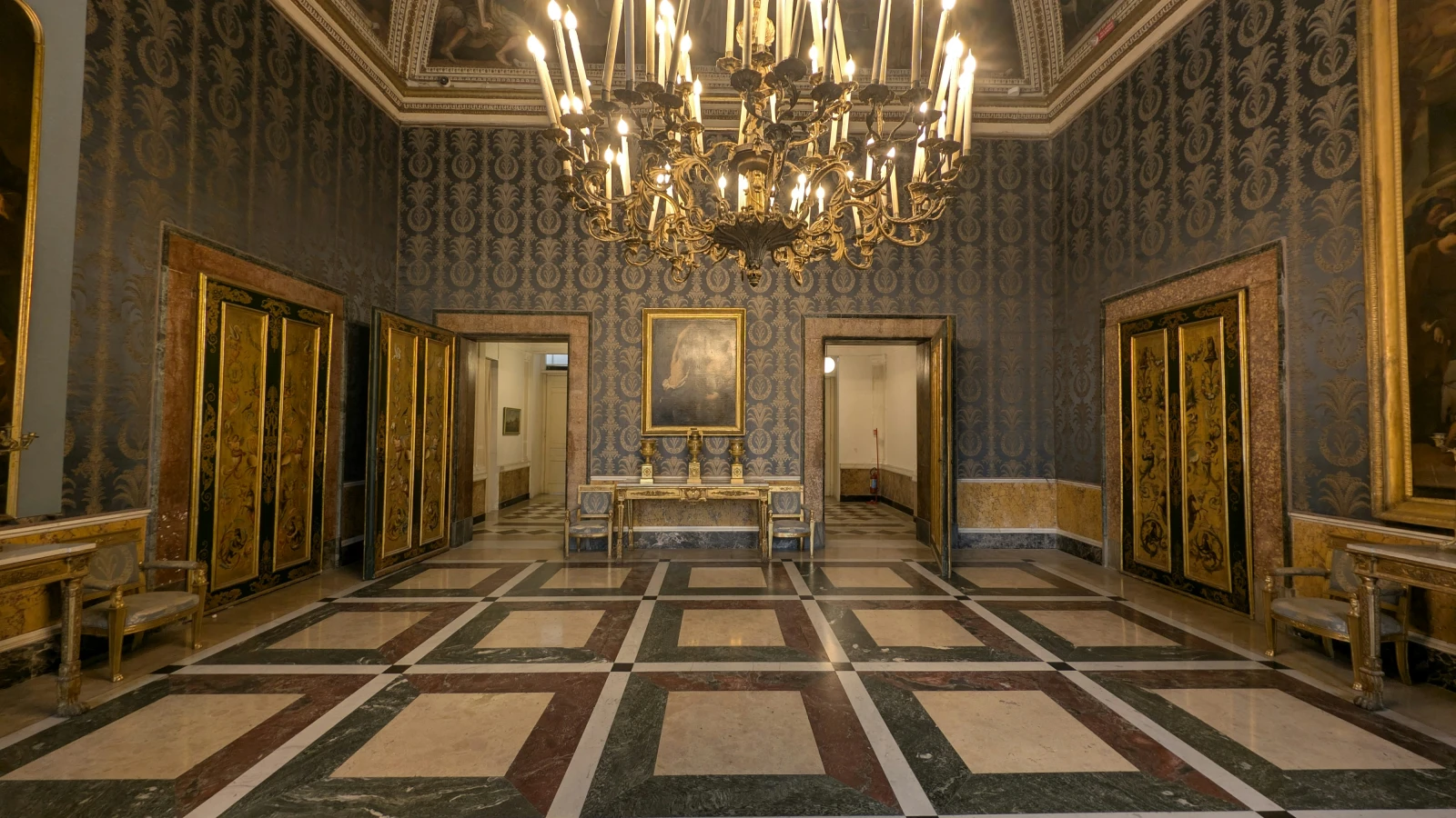 Ornate chandelier illuminating grand hall at the Royal Palace of Naples Palazzo Reale
